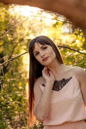Attractive young female posing in a summer parkの写真素材