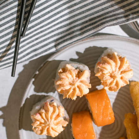 Japanese sushi rolls served on plate on gray background