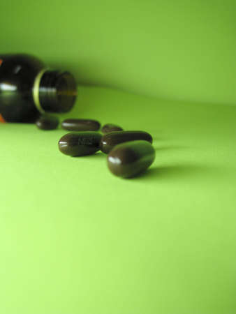 a bottle of pills on a green backgroundの写真素材