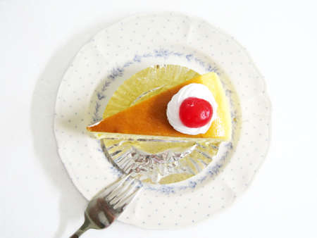 top view for a slide of cheese cake with cherry on topの写真素材