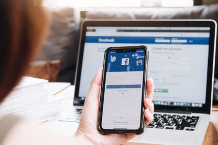 CHIANGMAI, THAILAND - AUG 26,2018 : A women holds Apple iPhone X with Facebook In application on the screen.Facebook is a photo-sharing app for smartphones.のeditorial素材
