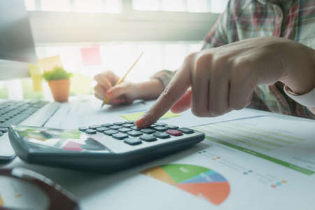 Woman using calculator while working for financial documents