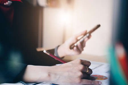 Close up Business woman using smart phone for do math finance on wooden desk in office and business working background, tax, accounting, statistics and analytic research conceptの写真素材