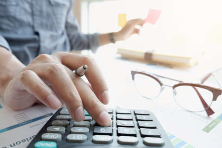 businessman or accountant hand working on calculator to calculate financial data report, accountancy...