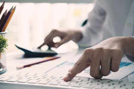 Close up view of bookkeeper or financial inspector hands making report, calculating or checking...