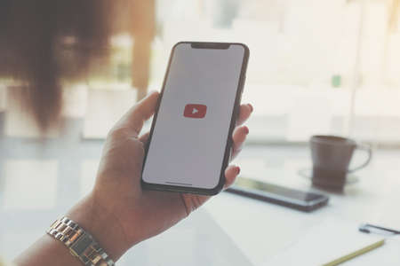 CHIANG MAI, THAILAND - MAR 7 2020 : Woman holding iPhone Xs with Youtube apps on screen. YouTube is the popular online video sharing website.のeditorial素材