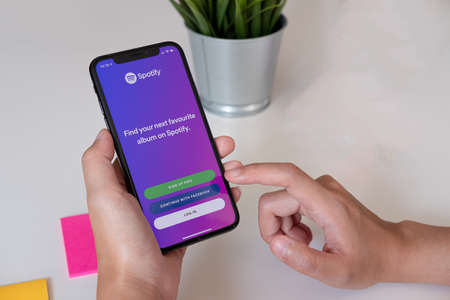 CHIANG MAI ,THAILAND JUL 27 2019 : Woman hand holding iPhone Xs with Spotify login screen. Spotify is a music service that offers legal streaming music.のeditorial素材