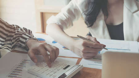 Businesswoman pointing graph chart with pathner for analyze plans in this mounth.