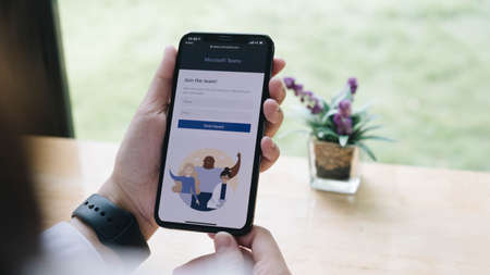CHIANG MAI, THAILAND - JUN 7 , 2020 : A girl mobile phone ready to use Teams to hold online classes. There has been a surge to Teams in the THAI and Asian recently due to Coronavirus lockdowns.のeditorial素材