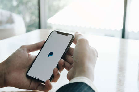 CHIANG MAI, THAILAND - JUL 25, 2020 : Woman hands holding iphone Xs with PayPal apps on the screen. PayPal is an online electronic payment system.のeditorial素材