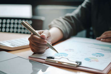 attractive woman writing in notepad while watching webinar on laptopの写真素材