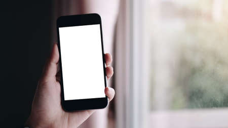 Close up Woman hand Using a Smart Phone with blank screen at home.