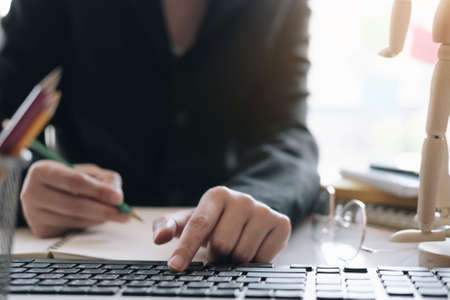 Business woman working in finance and accounting Analyze financial budget with calculator and laptop computer in the officeの写真素材