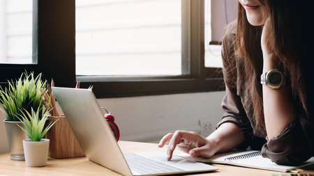 Business woman using laptop computer and calculator for do math finance on wooden desk in office and business working background, tax, accounting, statistics and analytic research conceptのeditorial素材