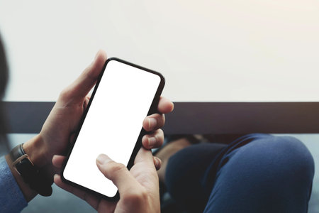 Top view man sitting and holding blank screen mock up mobile phoneの写真素材