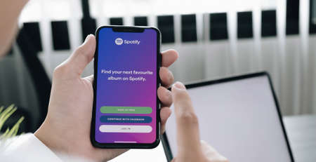CHIANG MAI, THAILAND - JUL 28 2020: Person holding a brand new Apple iPhone XS with Spotify logo on the screen. Spotify is a popular commercial music streaming service.のeditorial素材
