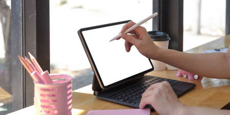 Close up of Woman holding new version digital tablet device in hands with smart pencil.