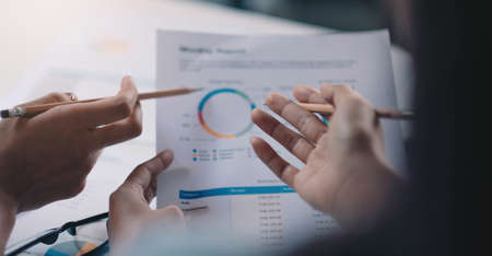 Close up business people discussing the charts and graphs showing the results of their successful...