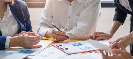 Close up of businessman or accountant hand holding pen working on calculator to calculate business...