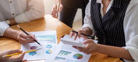 Close up of businessman or accountant hand holding pen working on calculator to calculate business...