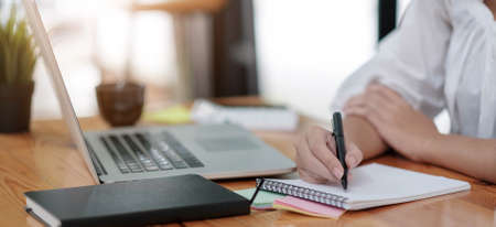 Close up cropped of woman using smartphone, calculating bills, browsing online banking service,...