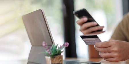Close up cropped of woman using smartphone, calculating bills, browsing online banking service,...
