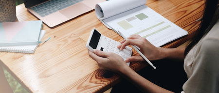 Close up Businessman using calculator and laptop for calaulating finance, tax, accounting,...
