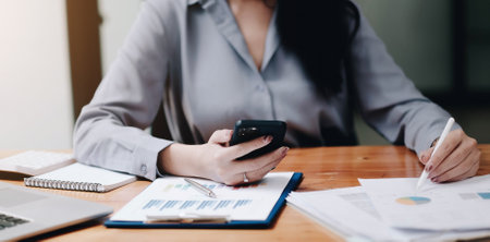 business woman using smartphone to analyze financial data.