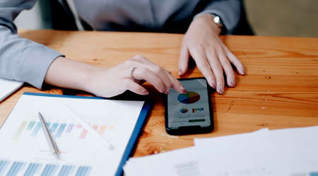 business woman using smartphone to analyze financial data.の写真素材
