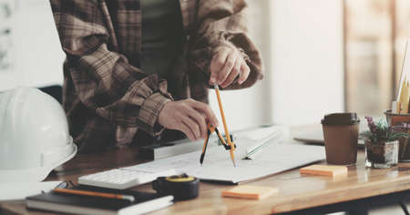 Concept architects, engineer holding pen pointing equipment architects On the desk with a blueprint in the office.の写真素材