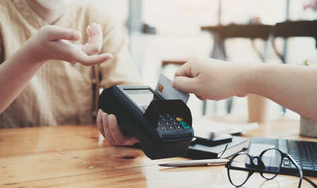 Close-up of asian customer using his credit card to swipe with EDC to pay, shopping with credit card conceptの写真素材