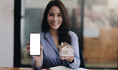 Portrait of a smiling Asian entrepreneur standing behind her cafe counter with open sign boardの写真素材