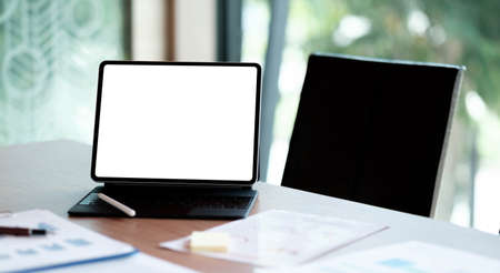 Digital tablet with white blank screen on table. workspace in modern office concept.