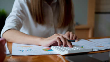 Cropped photo hand of woman writing making list taking notes in notepad working or learning online with laptop at homeの写真素材