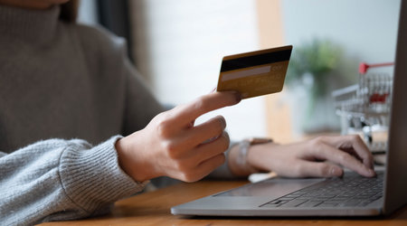 Close up of woman is hands holding cell telephone and credit card with blank copy space scree for...