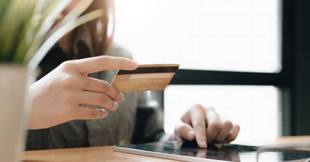 Online payment,woman's hands holding smartphone and using credit card for online shopping. Cyber...