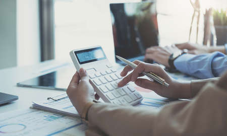 Closeup image of a woman writing and taking note on notebook in office, accounting financial concept