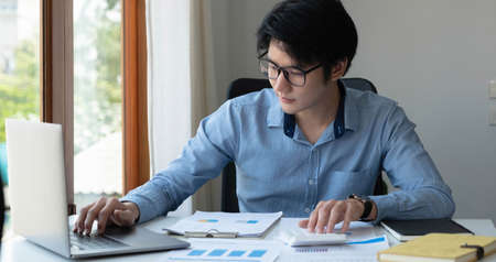 Portrait of Young Asian man hand freelancer is working her job on computer tablet in modern office....