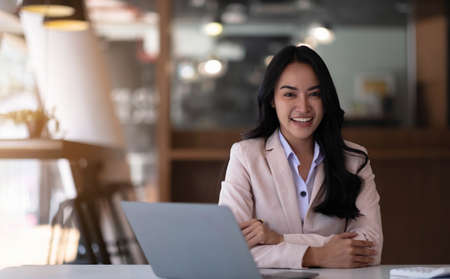 Charming asian businesswoman sitting working on laptop in office.の写真素材