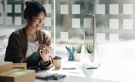 Startup small business entrepreneur SME, asian woman packing cloth in box. Portrait young Asian...