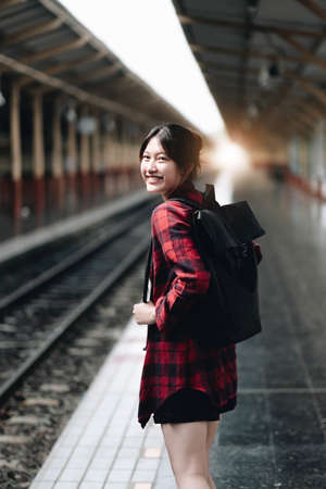 Young traveler woman looking for friend planning trip at train station. Summer and travel lifestyle...