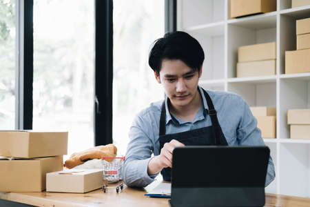 The seller Asian young man prepares the delivery box for the customerの写真素材