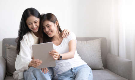 A couple of lovely woman listening song and watch movie with laptop   in bed while smiling and...