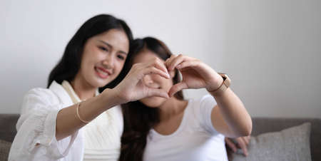 A couple of lovely woman listening song and watch movie with laptop   in bed while smiling and...