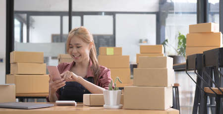 Female startup small business owner standing with smiles at camera. Online selling. E-commerce.