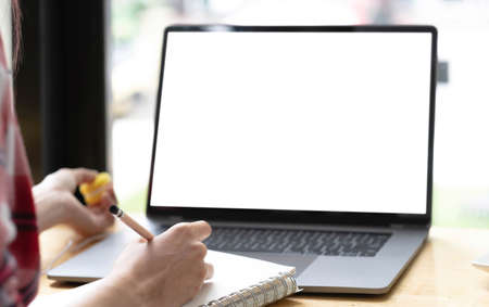 Young man working on his laptop with blank copy space screen for your advertising text message in office, Back view of business man hands busy using laptop at office deskの写真素材