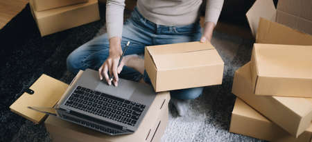 Close up Businesswoman using calculator and laptop for calaulating finance, tax, accounting,...