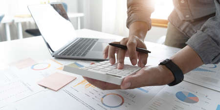 Close up businessman hand using calculator and working with laptop calculate about finance...