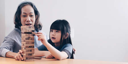 Little girl with her grandma playing game at homeの写真素材