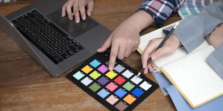 Two artists working on tablet, colour paper tone on workspace at the office